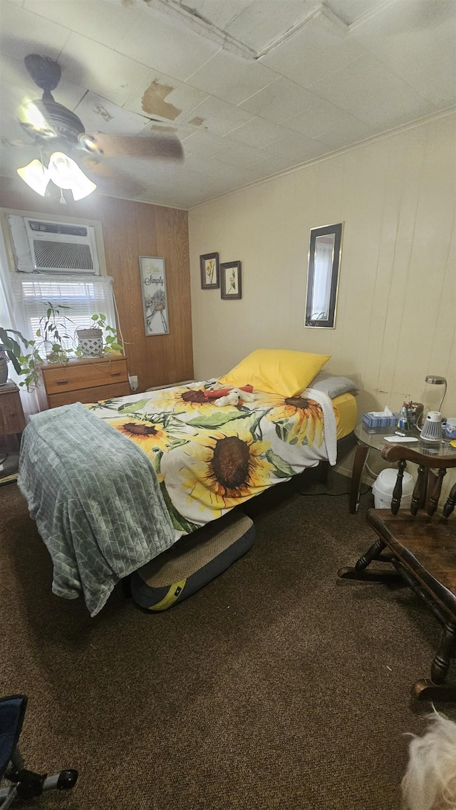 bedroom with a wall mounted air conditioner, carpet floors, ceiling fan, and wood walls