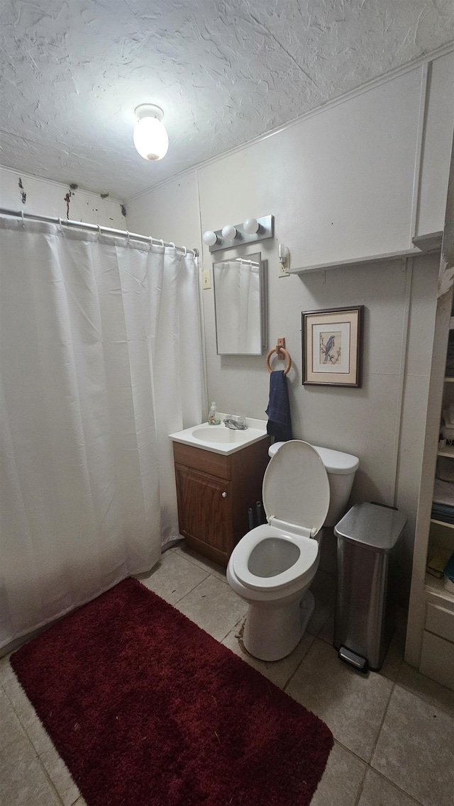 bathroom featuring a shower with shower curtain, tile patterned floors, a textured ceiling, vanity, and toilet