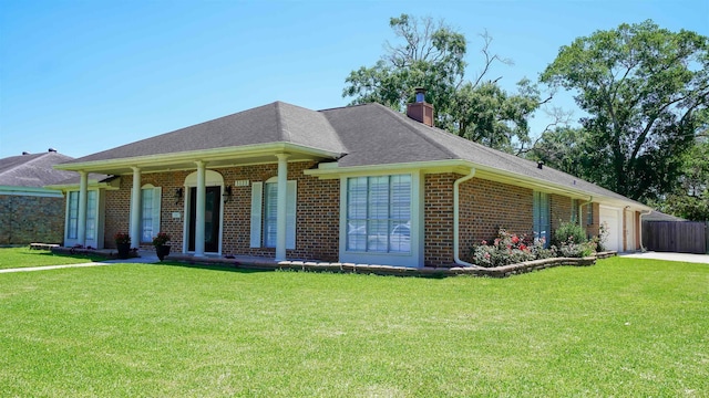 ranch-style home with a front yard, brick siding, a chimney, and a garage