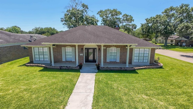 view of front of home with a porch, a shingled roof, brick siding, and a front lawn