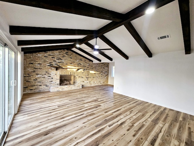 unfurnished living room with light hardwood / wood-style flooring, ceiling fan, plenty of natural light, and brick wall