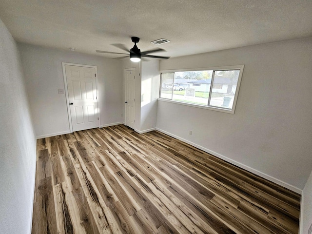 unfurnished room with hardwood / wood-style flooring, ceiling fan, and a textured ceiling