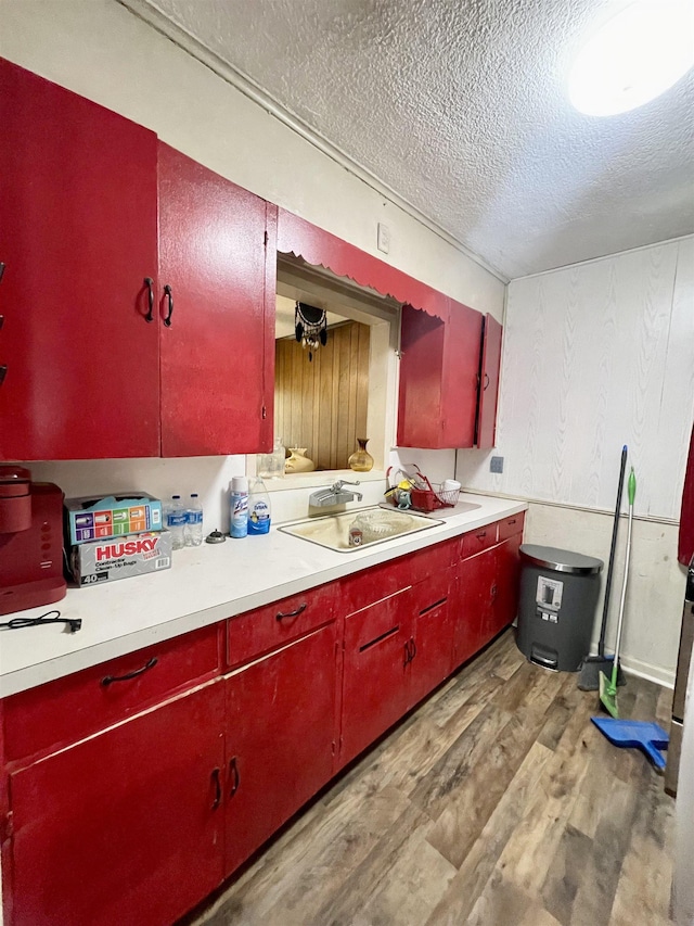 kitchen featuring sink, a textured ceiling, and light hardwood / wood-style flooring