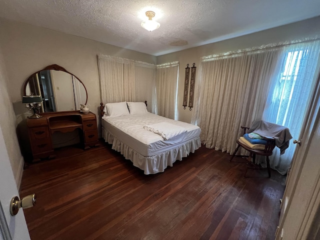 bedroom featuring a textured ceiling and dark wood-type flooring