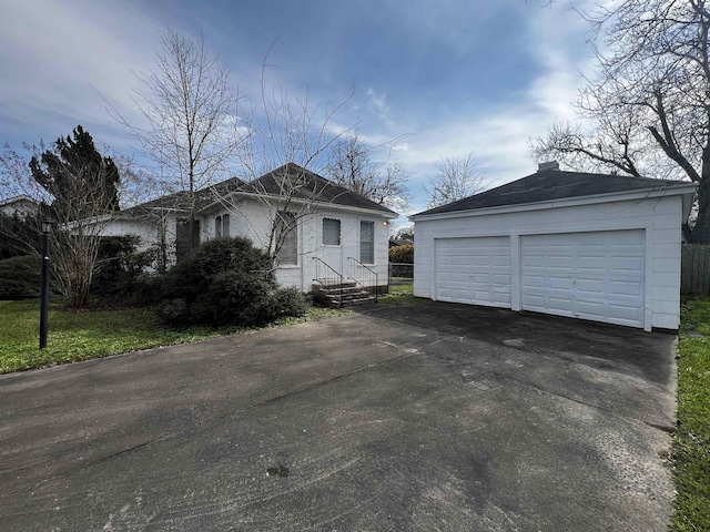 view of front of property with a garage and an outbuilding