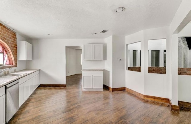 kitchen featuring white cabinets, stainless steel dishwasher, sink, and hardwood / wood-style flooring