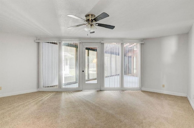 carpeted spare room with ceiling fan and a textured ceiling