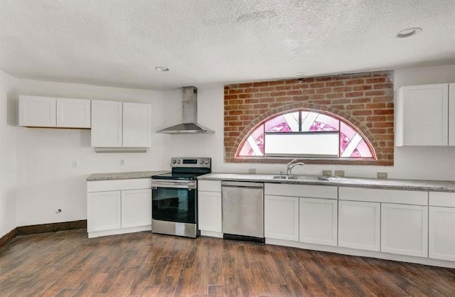 kitchen featuring sink, white cabinetry, wall chimney exhaust hood, dark hardwood / wood-style flooring, and appliances with stainless steel finishes