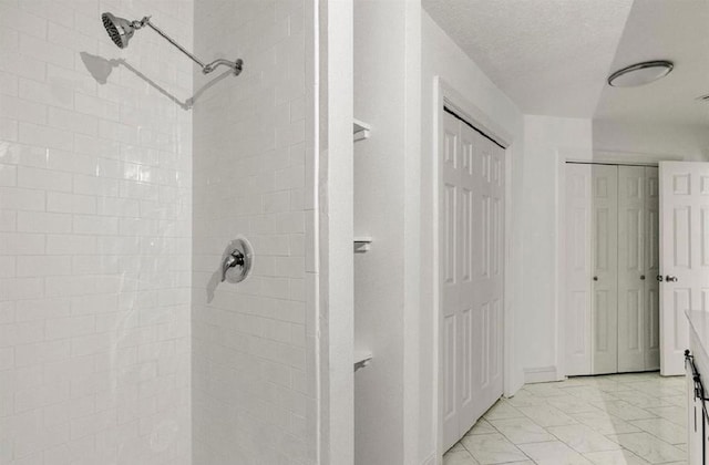 bathroom with a textured ceiling and a shower