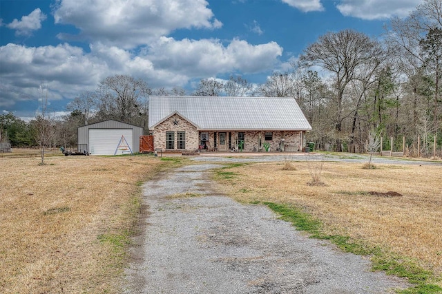 view of front facade featuring a garage, an outdoor structure, and a front yard