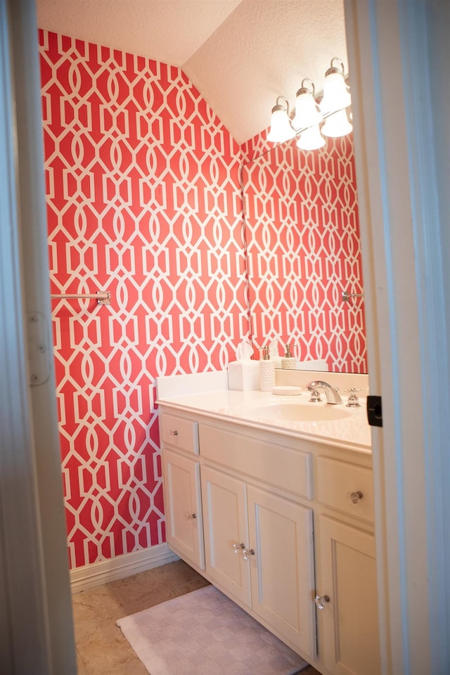 5065 Oakmont Dr, Beaumont, TX 77706 - bathroom with wallpapered walls, lofted ceiling, vanity, and a textured ceiling