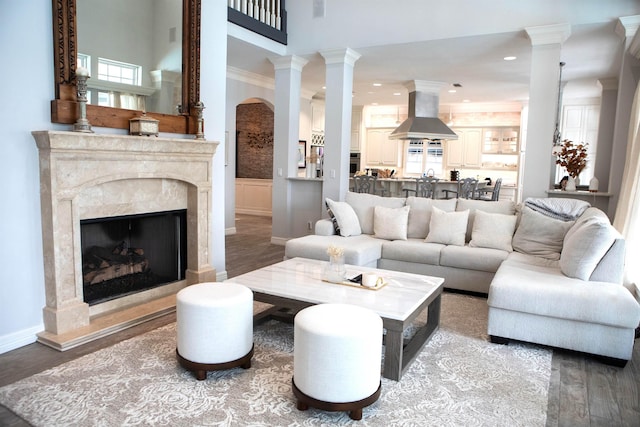 5065 Oakmont Dr, Beaumont, TX 77706 - living area with a high end fireplace, wood finished floors, decorative columns, recessed lighting, and a towering ceiling