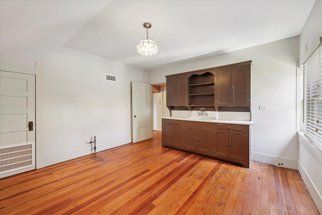507 Orange Ave, Orange, TX 77630 - kitchen with open shelves, light wood-style flooring, light countertops, decorative light fixtures, and lofted ceiling