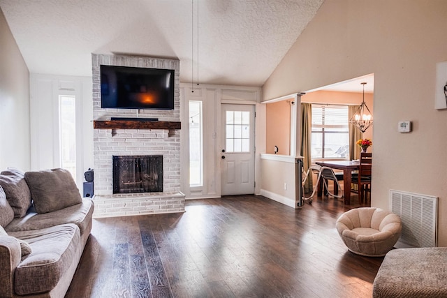 living room with lofted ceiling, a fireplace, dark wood-type flooring, and a textured ceiling