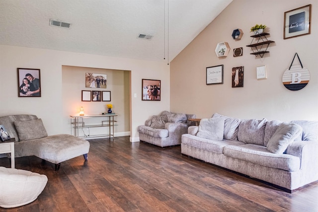 living room featuring dark hardwood / wood-style flooring, vaulted ceiling, and a textured ceiling