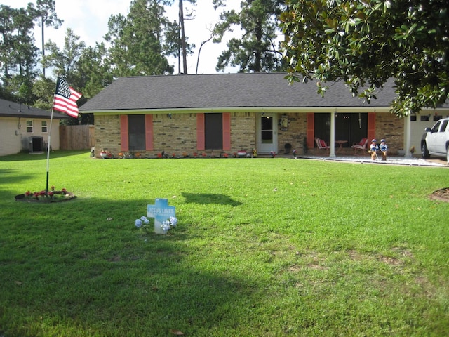 ranch-style home with a front lawn and central air condition unit