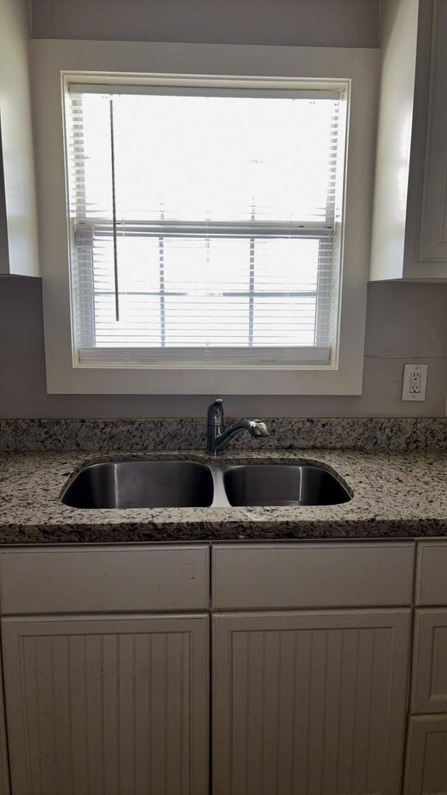 5440 Margo Ln, Beaumont, TX 77708 - kitchen with a wealth of natural light, a sink, and light stone countertops