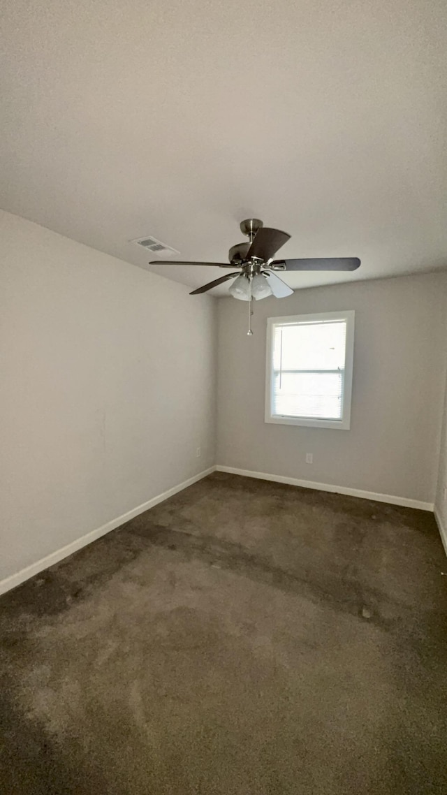 5440 Margo Ln, Beaumont, TX 77708 - empty room featuring baseboards, visible vents, dark colored carpet, and ceiling fan