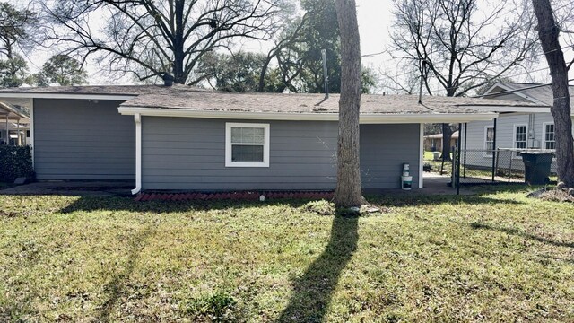 5440 Margo Ln, Beaumont, TX 77708 - back of house with a lawn, a carport, and fence