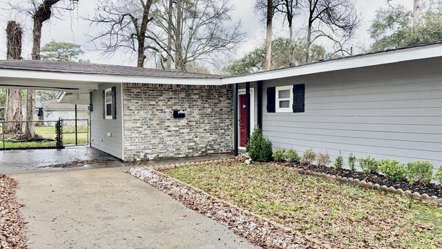 5440 Margo Ln, Beaumont, TX 77708 - property entrance featuring brick siding, driveway, a carport, and fence