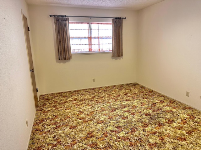 carpeted empty room with a textured ceiling