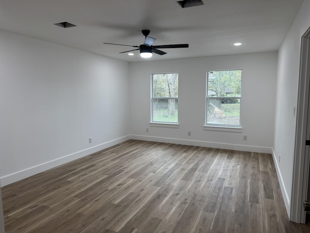 empty room with hardwood / wood-style floors and ceiling fan