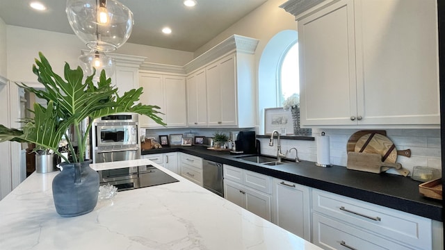 kitchen featuring hanging light fixtures, white cabinetry, sink, and stainless steel appliances