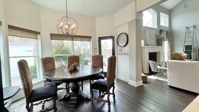 dining area featuring a high ceiling, plenty of natural light, dark wood-type flooring, and a notable chandelier