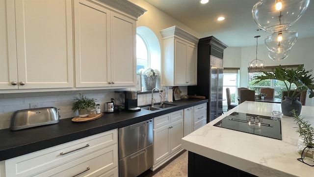 kitchen featuring pendant lighting, dishwasher, sink, white cabinets, and decorative backsplash