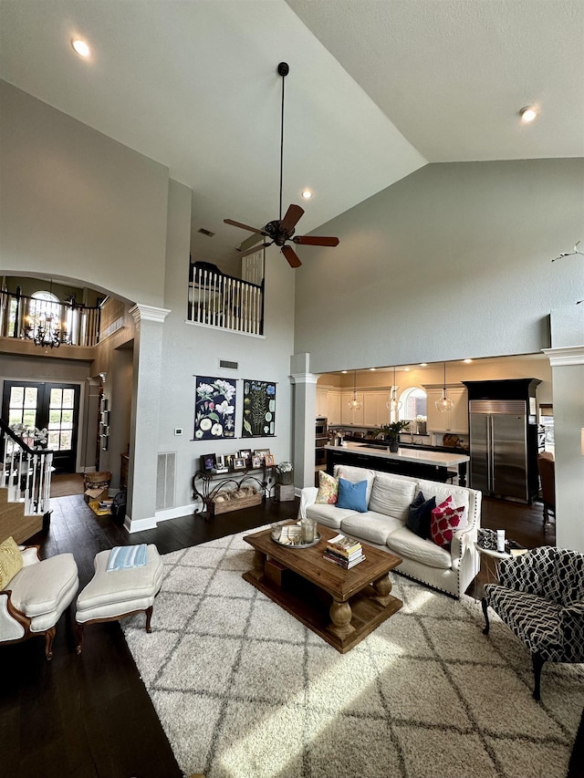 living room featuring dark wood-type flooring, high vaulted ceiling, and ceiling fan