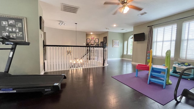 workout room with ceiling fan and dark hardwood / wood-style flooring