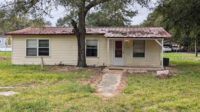 view of front of house with central AC and a front yard