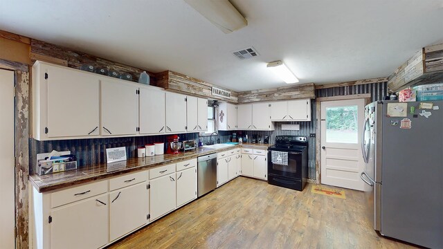 kitchen with white cabinets, appliances with stainless steel finishes, light hardwood / wood-style flooring, and sink