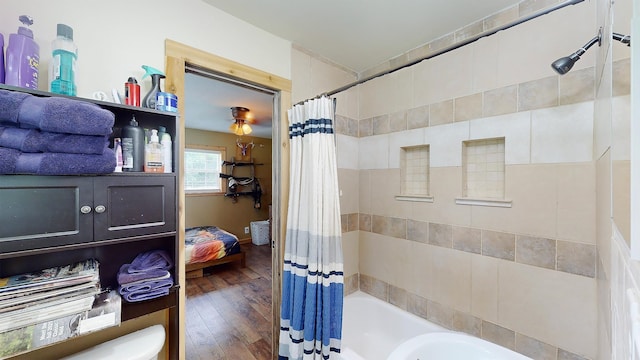 bathroom with hardwood / wood-style floors and shower / bathtub combination with curtain