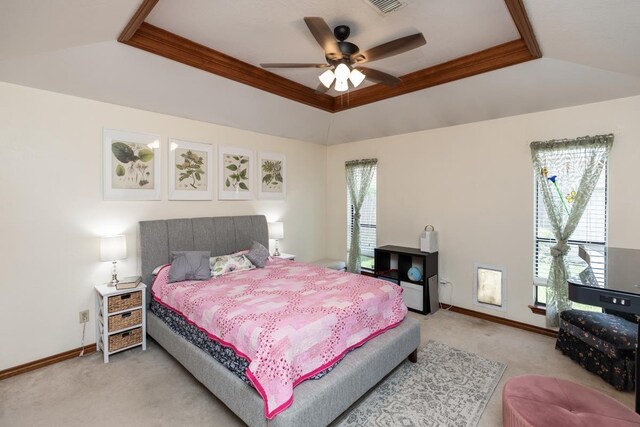 bedroom with light colored carpet, a raised ceiling, vaulted ceiling, and baseboards