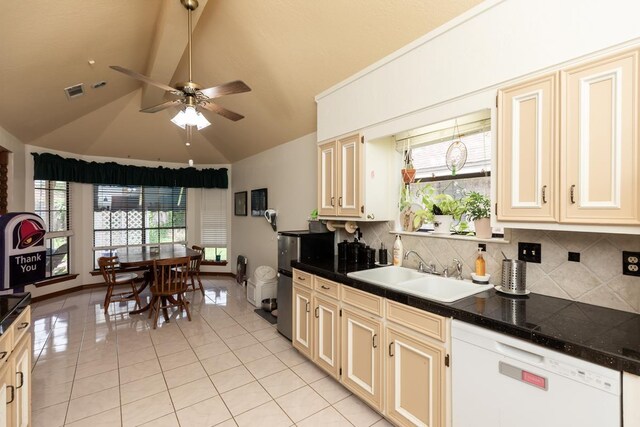 kitchen with a healthy amount of sunlight, white dishwasher, a sink, light tile patterned flooring, and lofted ceiling