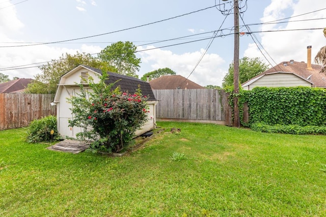 view of yard featuring an outdoor structure, a storage unit, and a fenced backyard