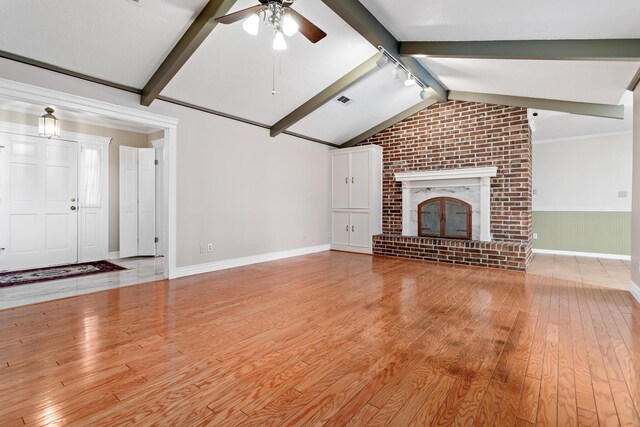 unfurnished living room featuring a fireplace, vaulted ceiling with beams, light hardwood / wood-style flooring, and ceiling fan