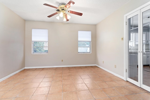 unfurnished room with light tile patterned floors, french doors, and ceiling fan