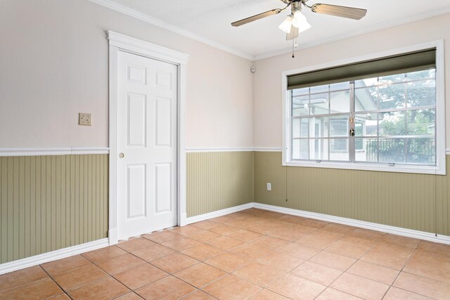 unfurnished room with ceiling fan, ornamental molding, and light tile patterned flooring