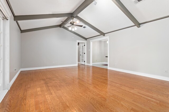 unfurnished living room with hardwood / wood-style floors, vaulted ceiling with beams, and ceiling fan