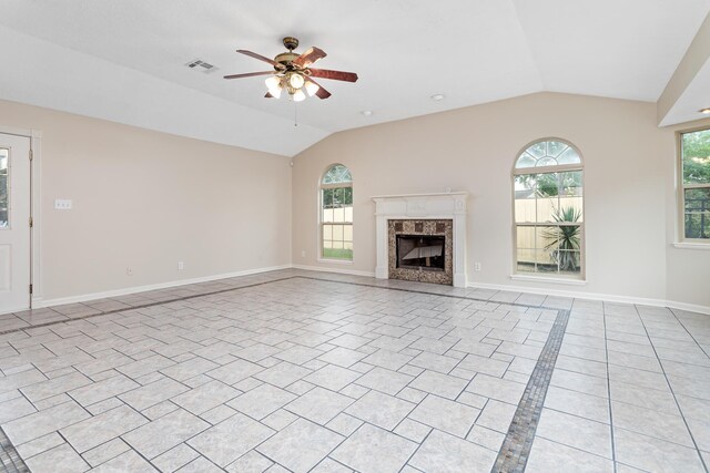 unfurnished living room featuring ceiling fan, lofted ceiling, light tile patterned floors, and a premium fireplace