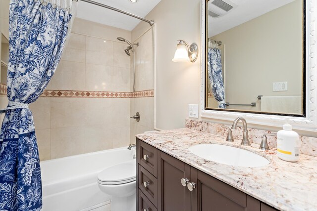 full bathroom featuring vanity, shower / bath combination with curtain, and toilet