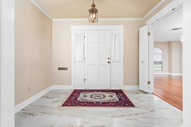 entrance foyer featuring a chandelier, a textured ceiling, and ornamental molding