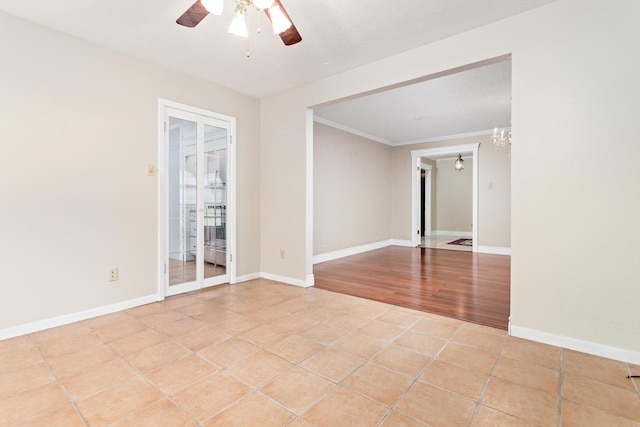 tiled spare room with ceiling fan with notable chandelier