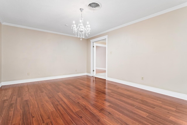 spare room with an inviting chandelier, ornamental molding, and hardwood / wood-style flooring