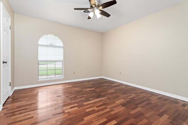 empty room with ceiling fan and dark hardwood / wood-style flooring