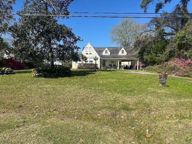 cape cod house featuring a carport and a front yard
