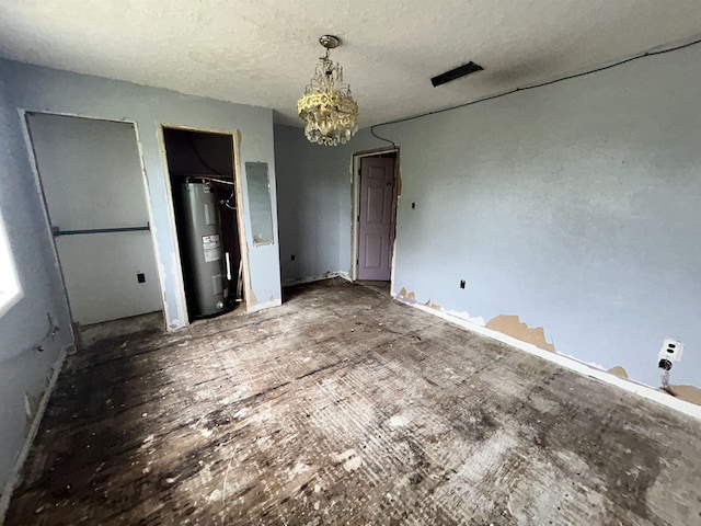 unfurnished bedroom with electric water heater, two closets, a notable chandelier, and a textured ceiling