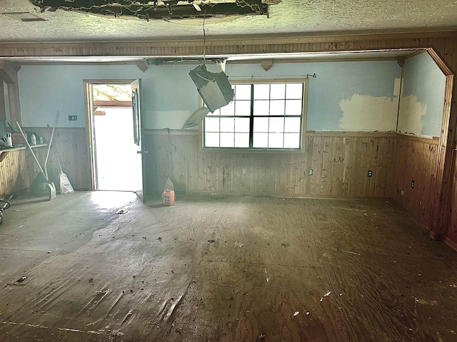 interior space featuring wood walls, wainscoting, and a healthy amount of sunlight